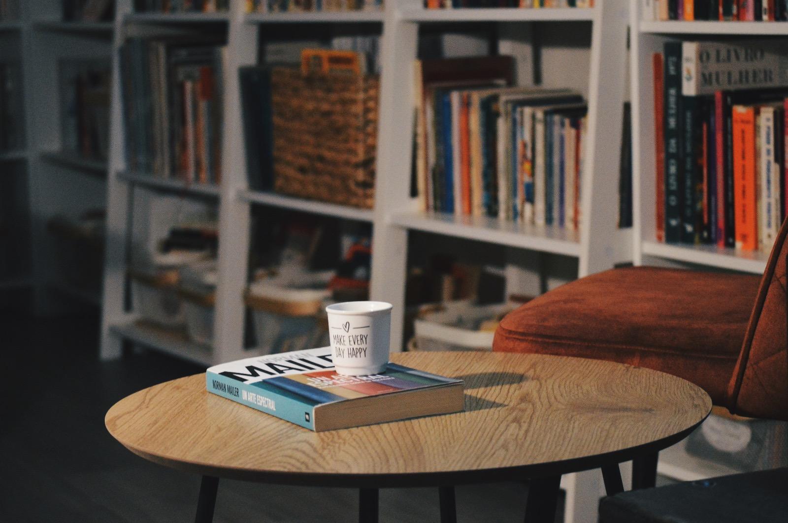 Sala de leitura da Tertúlia com poltronas e estantes de livros